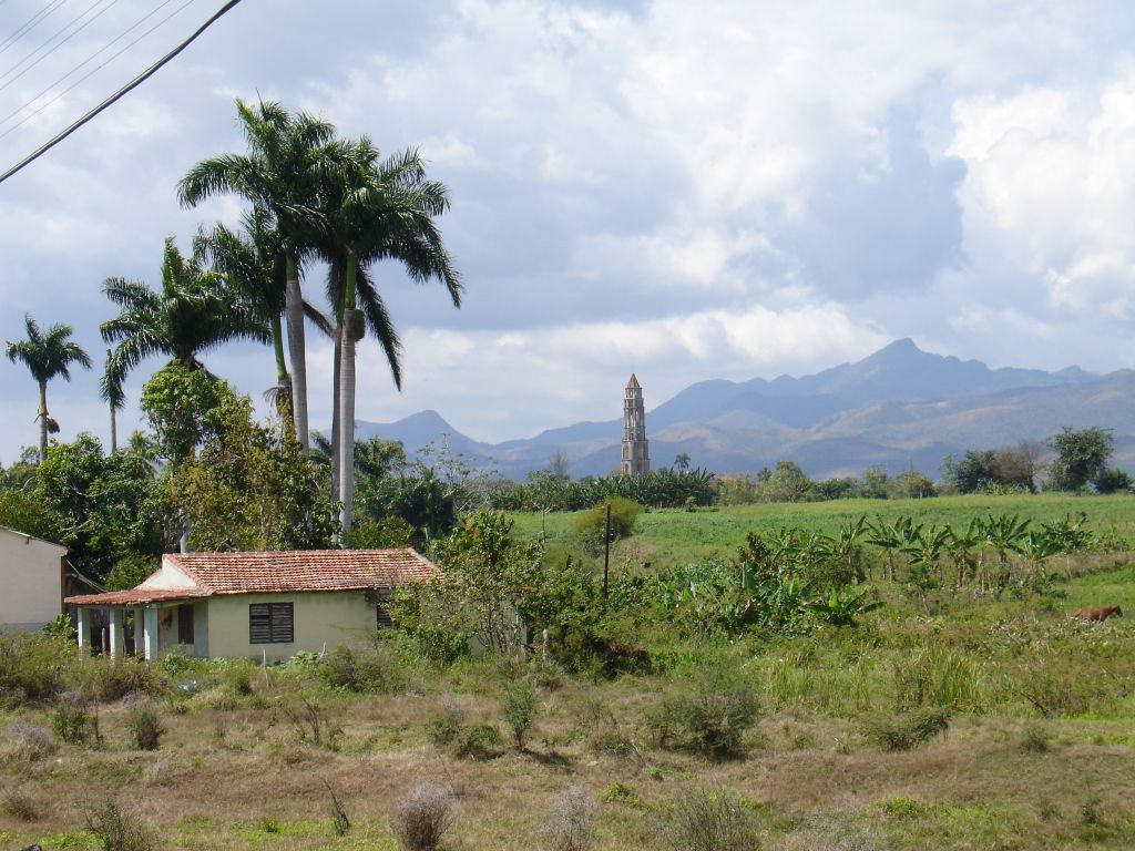 Vor den Bergen der Sierra de Escambray steht der Turm der Zuckerrohrplantage Manaca Iznaga. Von hier wurden die Sklaven auf den Feldern überwacht.