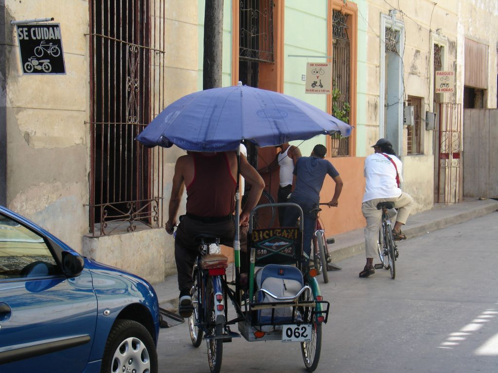 In Holguín haben die Fahrradtaxis meistens einen Sitz neben dem Fahrer. Dieses hat sogar eine Musikanlage unter dem Gepäckfach.<br />In den Häusern am Rand der Innenstadt gibt es viele bewachte Fahrradstellplätze.