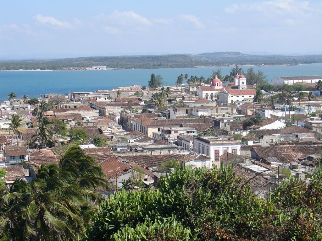 Vom Aussichtpunkt sieht man die Stadt mit Kirche und rechts der großen Lebensmittellagerhalle.<br />Auf der gegenüberliegenden Seite des Meeres der Strand, zu dem man als Tourist aber gerade nicht kam, weil das staatliche Boot kaputt war und es den Fischern verboten war, Touristen zu transportieren.