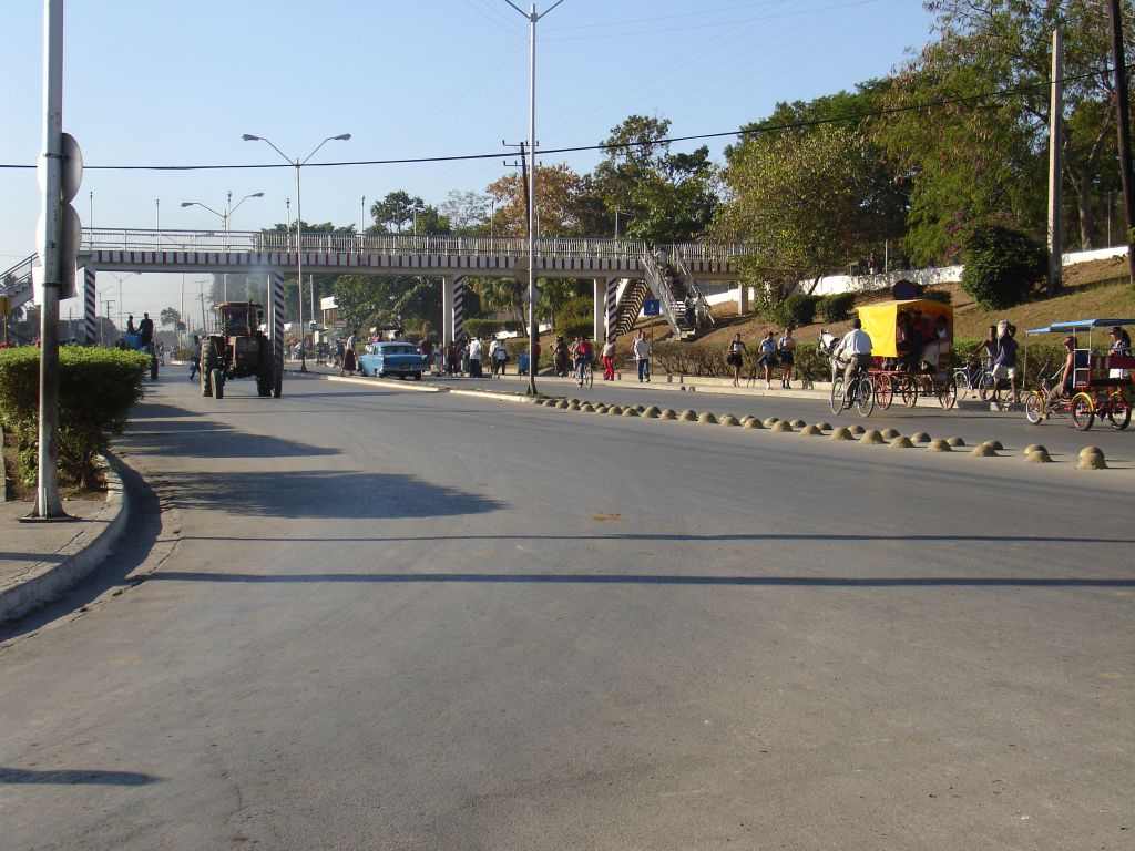 Der Verkehr auf einer der Einfallstraßen von Guantanamo beteht im Wesentlichen aus Kutschen und Fahrrädern. Hinzu kommen wenige Autos und Traktoren.<br />Trotzdem gibt es eine Fußgängerbrücke, um die Straße zu überqueren.