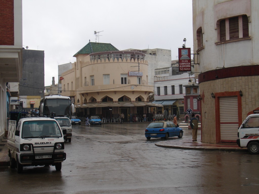 Abends kam ich dann in Al Hoceima an. Gleich am Ortseingang hat mich ein Polizist kontrolliert.<br />Das Hotel Etoile du Rif ('Stern des Rif-Gebirges') hat eine schöne Art-Deco-Fassade.<br />Rechts davor ein Petit Taxi, normalerweise ein Peugeot 205 oder 106. Dieser Typ von Taxis fährt nur innerorts.