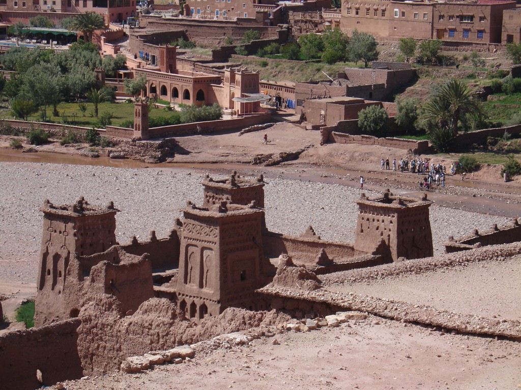 Hinter der Kasbah sieht man den Zugang zur Festung vom Ort und eine große Gruppe Touristen vor dem Überqueren des Flusses.