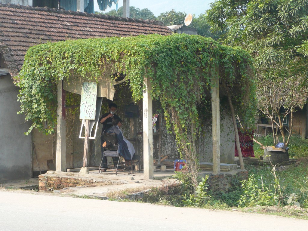 Ein Friseursalon mit offenen Seitenwänden, direkt neben der Straße.